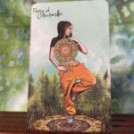 A young man standing on one leg, holding a giant coin in front of them.