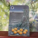 The tarot card the eight of cups depicted by a person walking away from 8 golden bowls on the ground